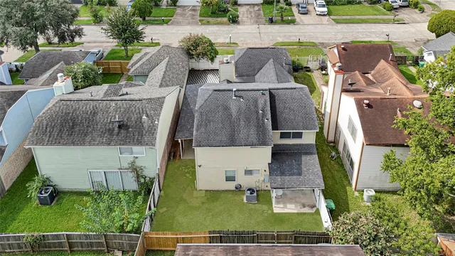 an aerial view of a house with swimming pool garden and tall buildings