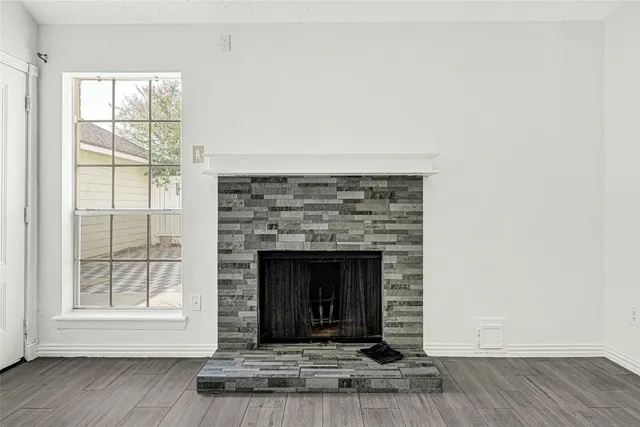 an empty room with wooden floor and a fireplace