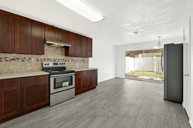 a kitchen with stainless steel appliances a refrigerator and a stove top oven