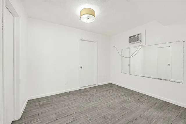 a view of a room with wooden floor and white walls