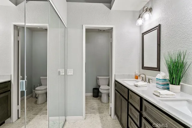 a bathroom with a granite countertop sink a toilet and a mirror