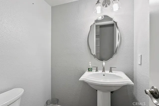a bathroom with a sink a mirror and toilet