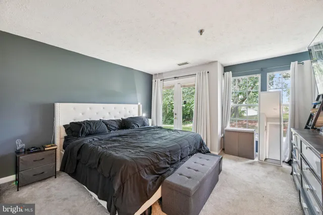 a bedroom with a bed and a flat tv screen on the dresser