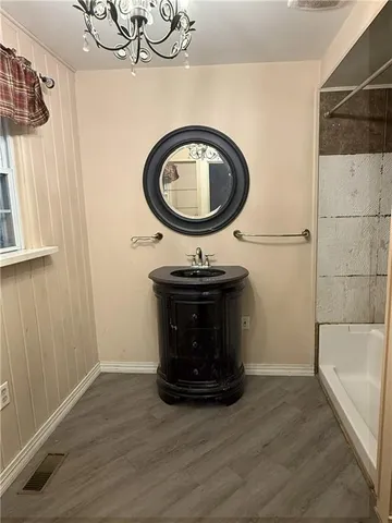 a bathroom with a sink a mirror and bathtub
