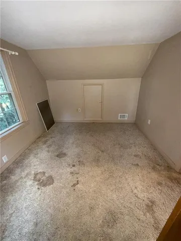 a view of a livingroom with an empty space and a window