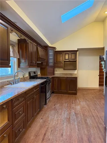 a kitchen with stainless steel appliances granite countertop a sink cabinets and wooden floor