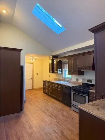 a large kitchen with stainless steel appliances granite countertop a stove and a sink