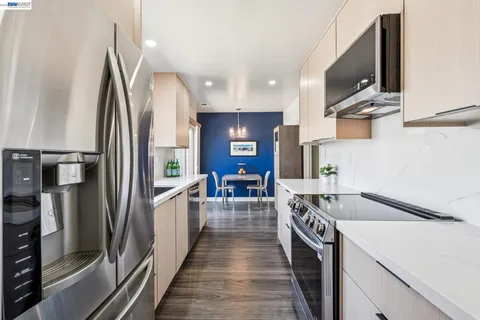 a kitchen with stainless steel appliances granite countertop a refrigerator and a stove