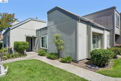 a view of a house with brick walls and a yard with plants