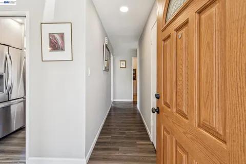 a view of a hallway with wooden floor and staircase