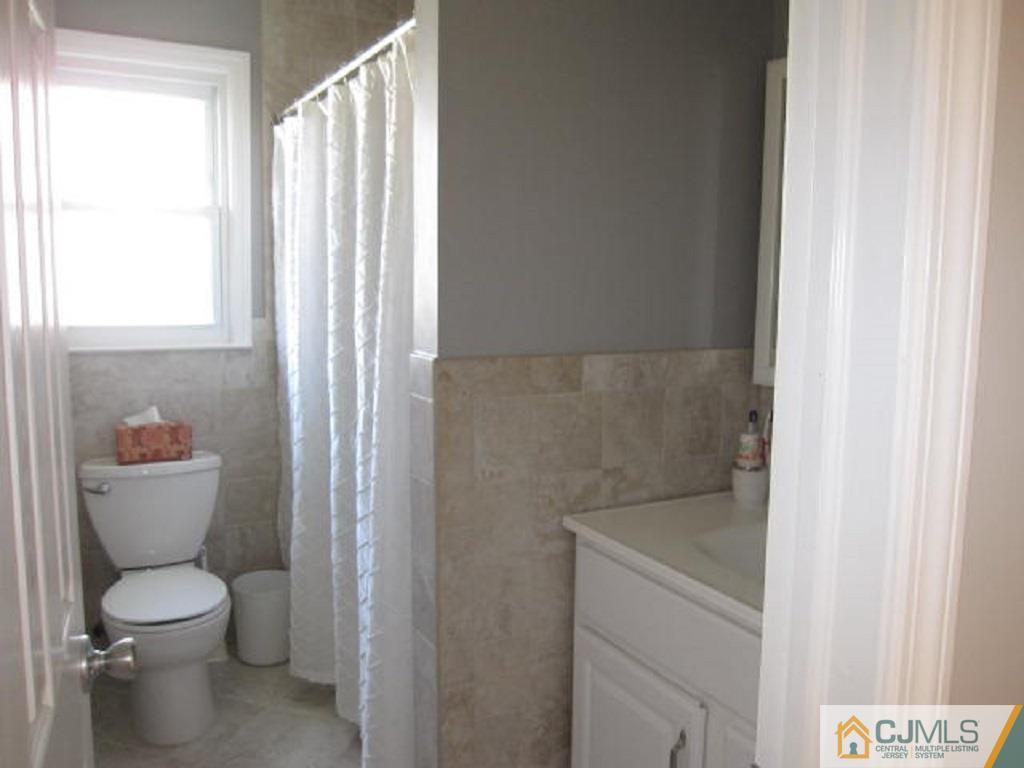 20 Mockingbird Road Edison, NJ 08820 - Photo 16 of 18 a bathroom with a toilet and a shower curtain