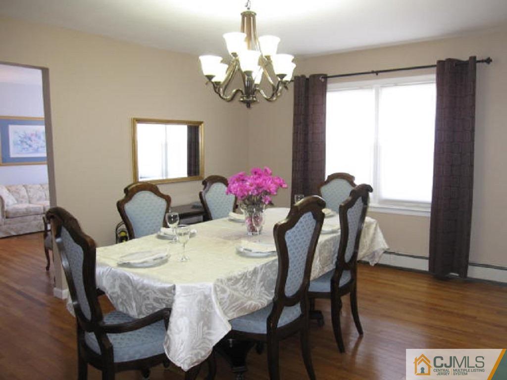 20 Mockingbird Road Edison, NJ 08820 - Photo 7 of 18 a view of a dining room with furniture a chandelier and wooden floor