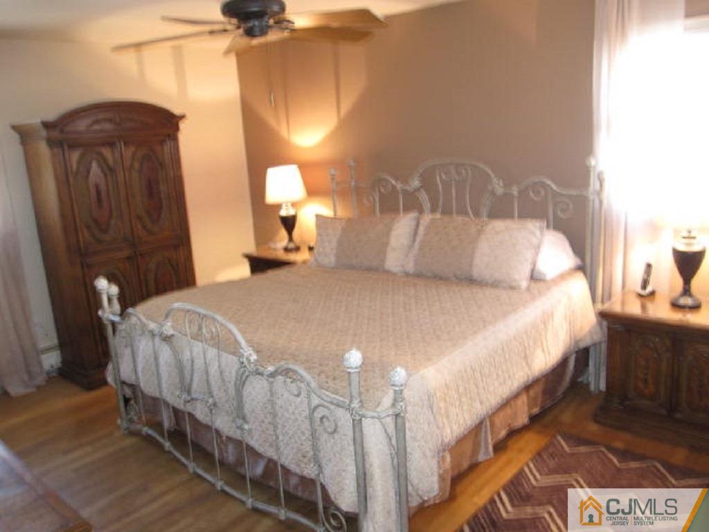 20 Mockingbird Road Edison, NJ 08820 - Photo 10 of 18 a large bed sitting in a bedroom next to a lamp