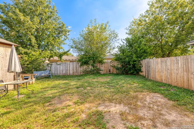 a backyard of a house with table and chairs