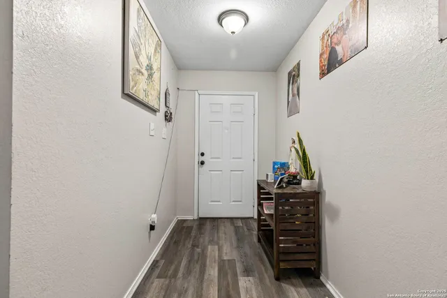 a view of a hallway with wooden floor and entryway