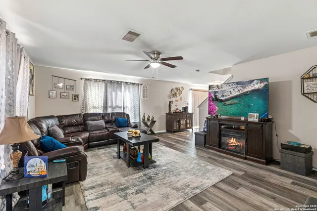 a living room with furniture a flat screen tv and a table