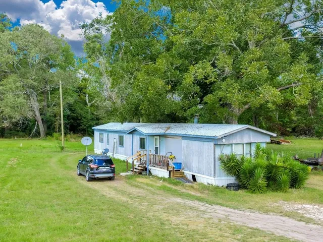 a view of a house with backyard and sitting area