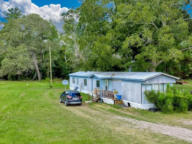 a car parked in front of a house with a yard