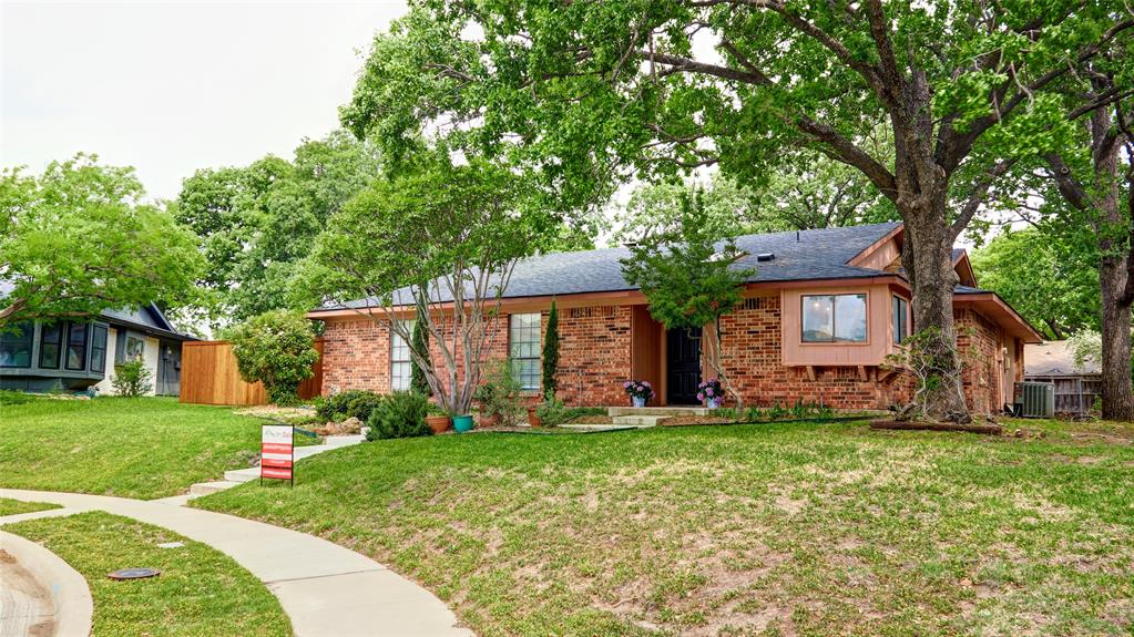 a front view of a house with a yard and trees