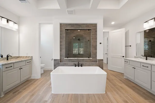 a bathroom with a double vanity sink a mirror and a bathtub
