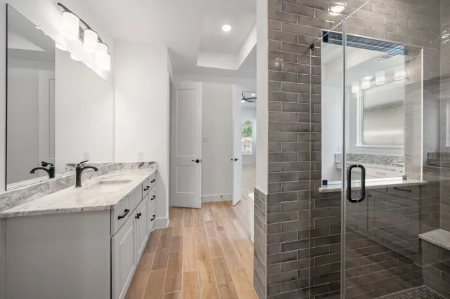 a bathroom with a double vanity sink a mirror and a shower