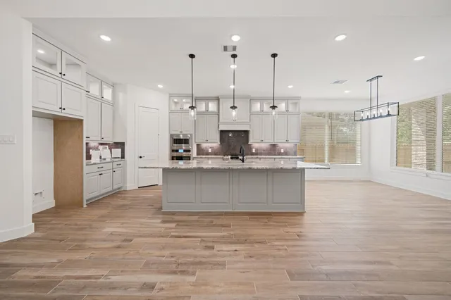 a view of kitchen with kitchen island white cabinets and stainless steel appliances