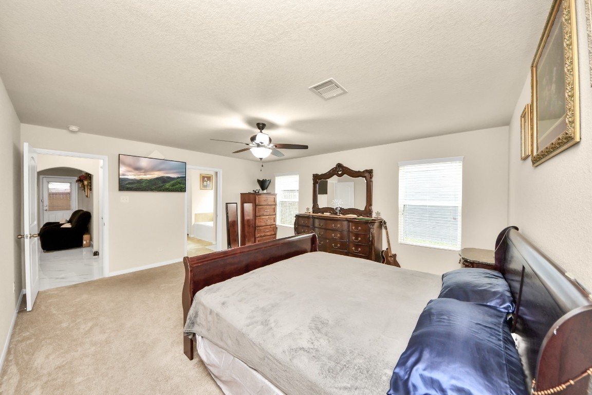 10207 Moonset Lane Houston, TX 77016 - Photo 14 of 34 a large bedroom with a large bed and flat tv screen