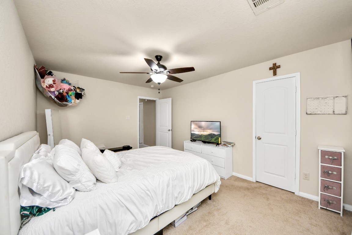 10207 Moonset Lane Houston, TX 77016 - Photo 18 of 34 a bedroom with a bed and a chandelier