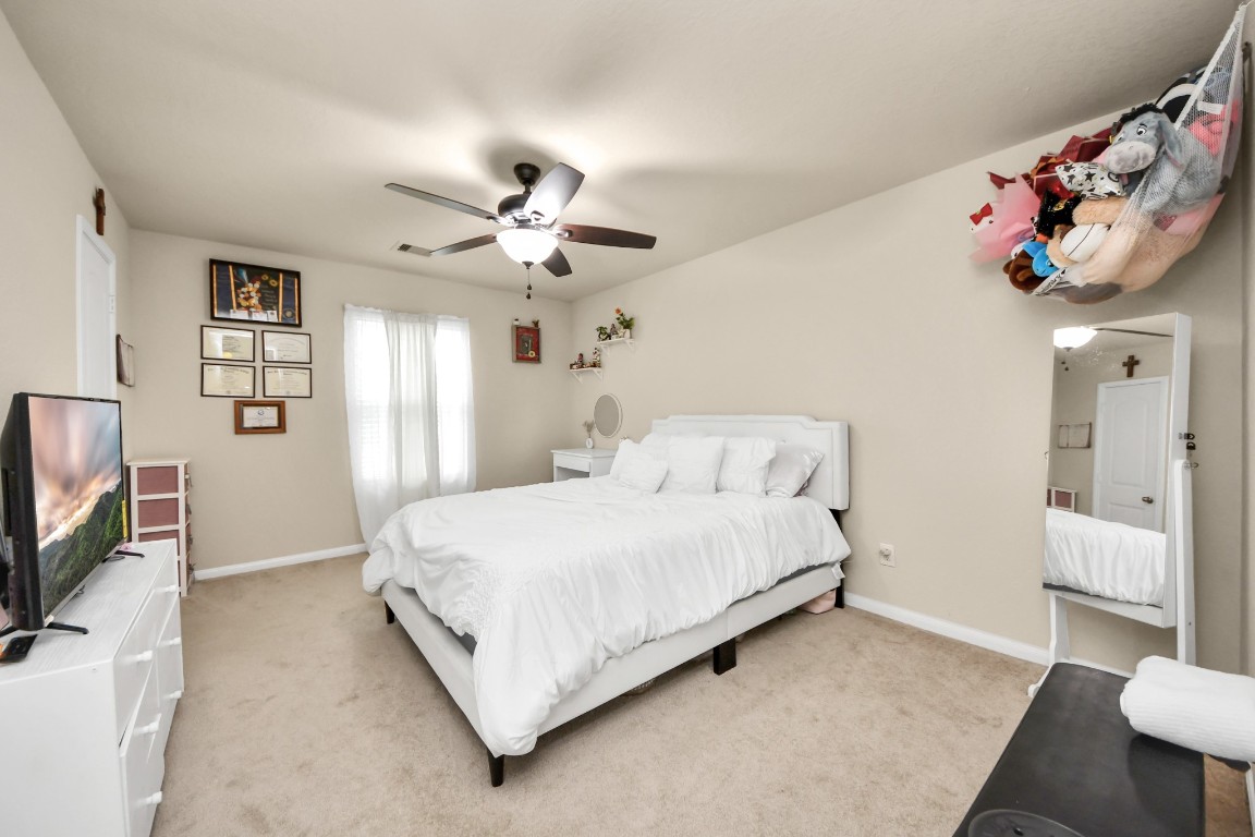 10207 Moonset Lane Houston, TX 77016 - Photo 19 of 34 a bedroom with a bed and a flat screen tv