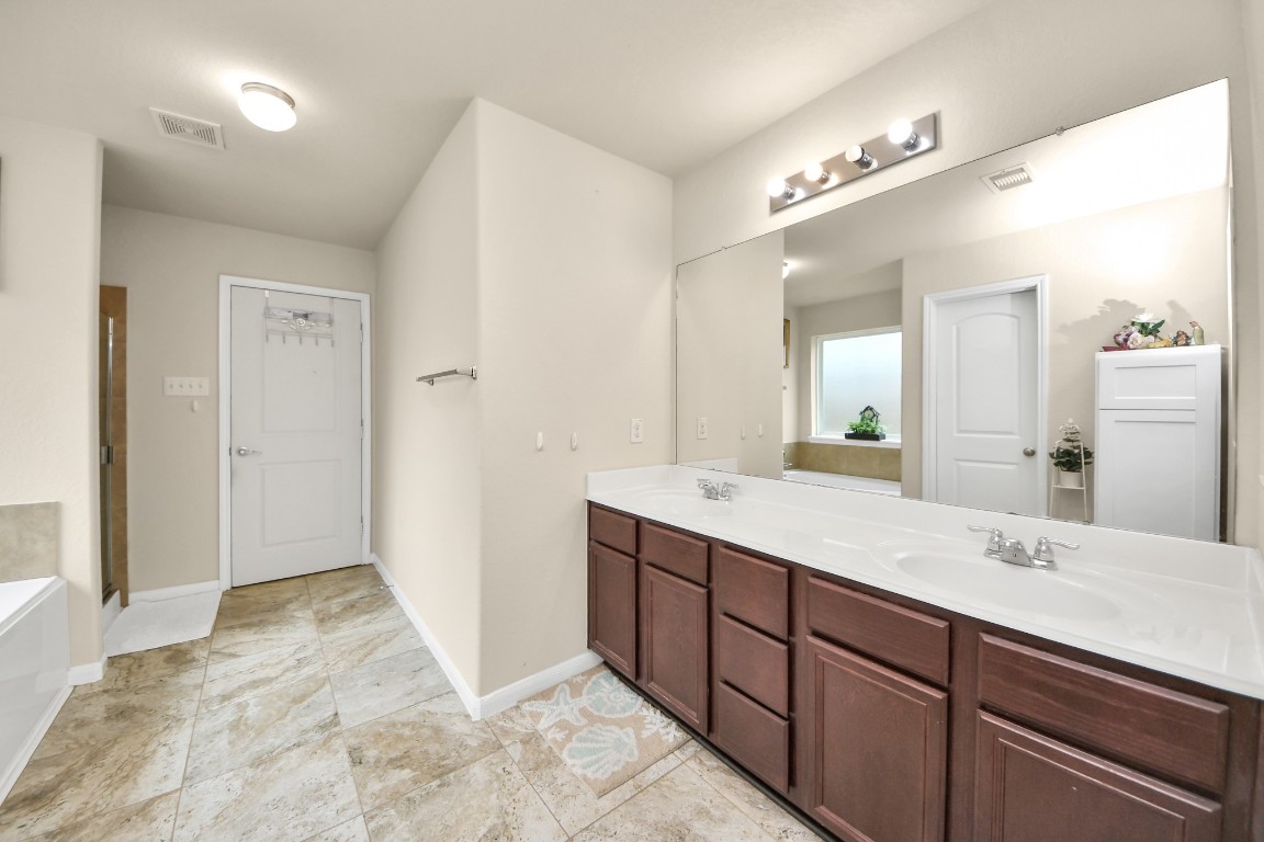 10207 Moonset Lane Houston, TX 77016 - Photo 21 of 34 a spacious bathroom with a double vanity sink and a mirror