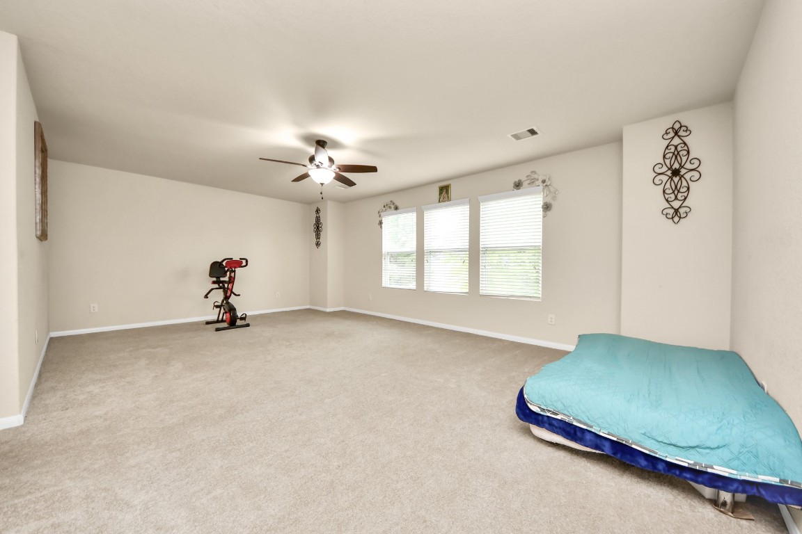 10207 Moonset Lane Houston, TX 77016 - Photo 25 of 34 an empty room with windows and ceiling fan