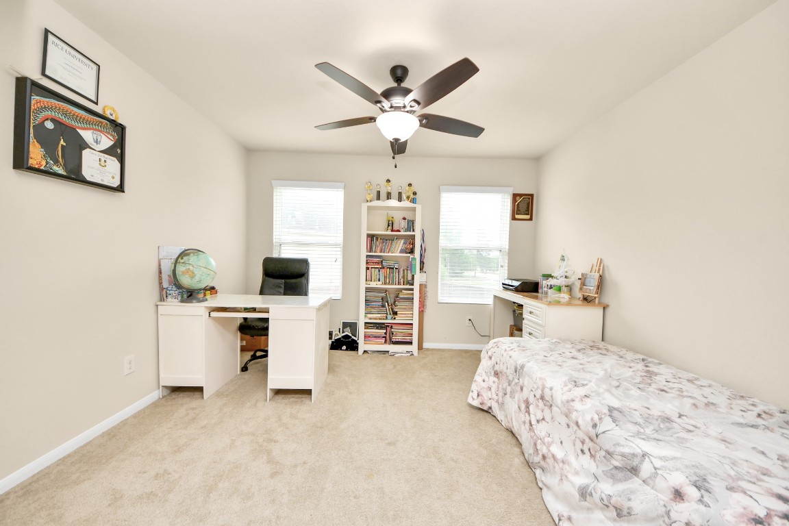 10207 Moonset Lane Houston, TX 77016 - Photo 26 of 34 a bedroom with a bed and a desk