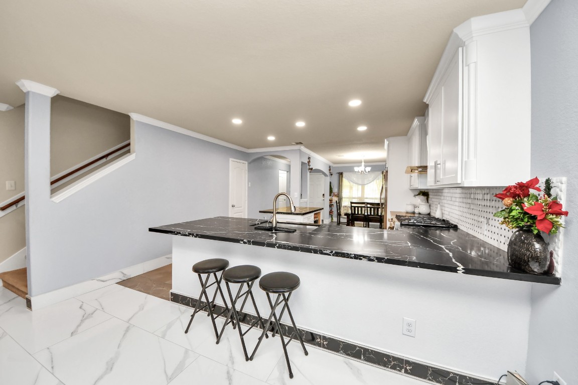 10207 Moonset Lane Houston, TX 77016 - Photo 6 of 34 a kitchen with stainless steel appliances granite countertop a sink a stove a dining table and chairs