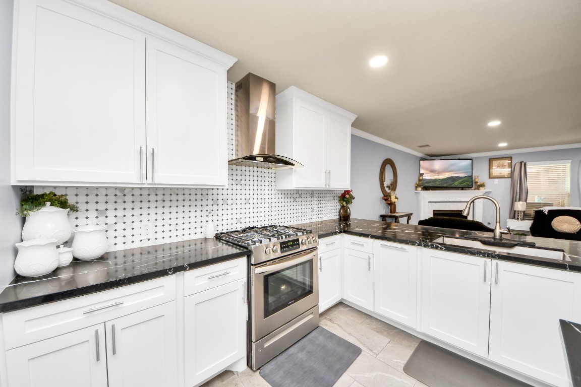 10207 Moonset Lane Houston, TX 77016 - Photo 7 of 34 a kitchen with granite countertop a sink a stove and cabinets