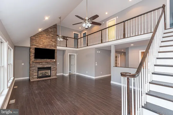 wooden floor in an empty room with a fireplace and a window