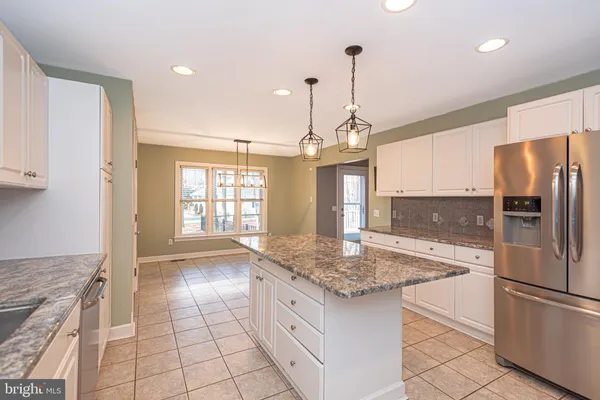 a kitchen with stainless steel appliances granite countertop a sink a stove a refrigerator and island