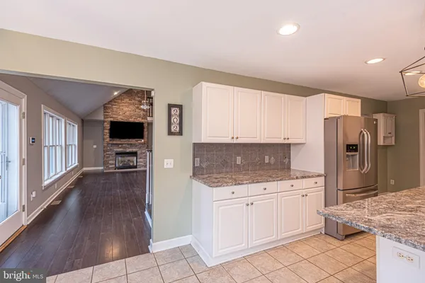 a kitchen with granite countertop a sink stove and refrigerator