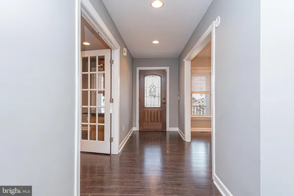 wooden floor with a window in a hall with an entryway