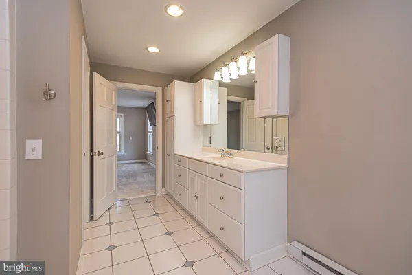 a bathroom with a double vanity sink mirror and bathtub
