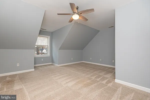 a view of an empty room with a ceiling fan and window