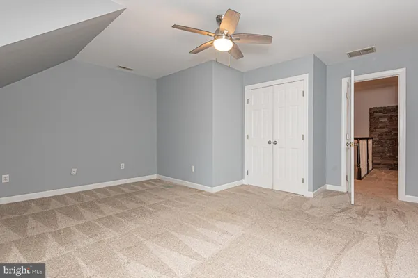 a view of a deck with large trees and wooden fence