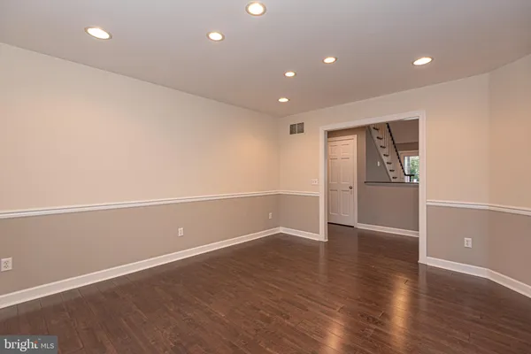 an empty room with wooden floor and white walls