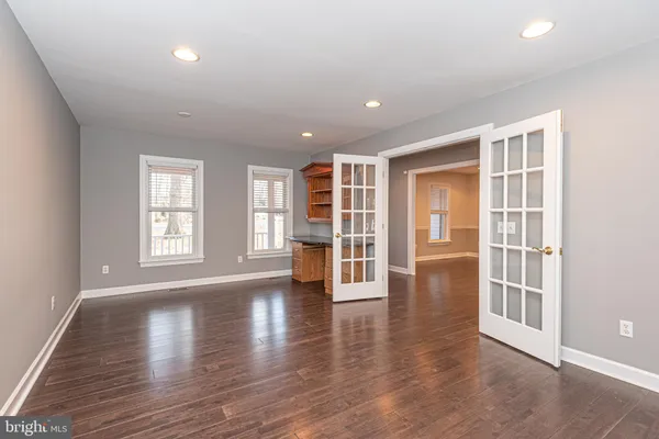 an empty room with wooden floor and a window