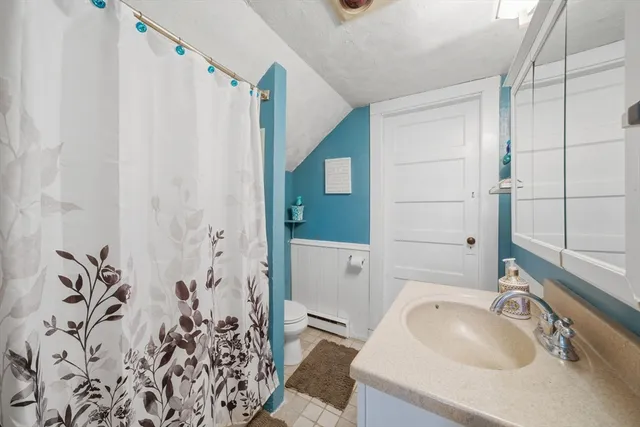 a bathroom with a sink and mirror with bathtub