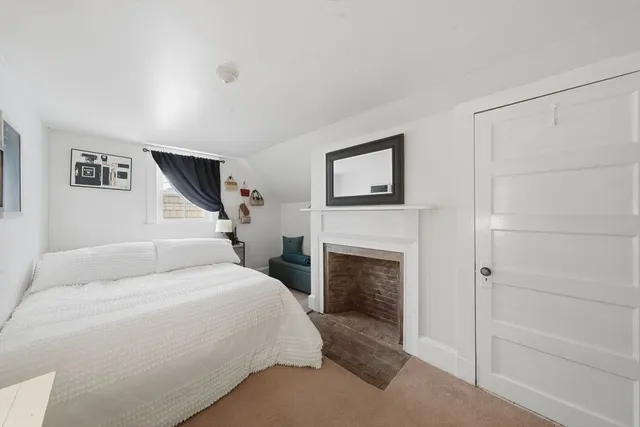 a bedroom with a large bed and a fireplace