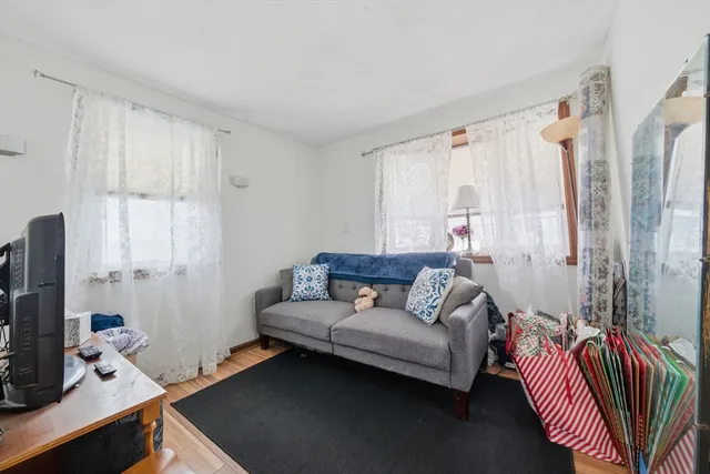a living room with furniture a flat screen tv and a window