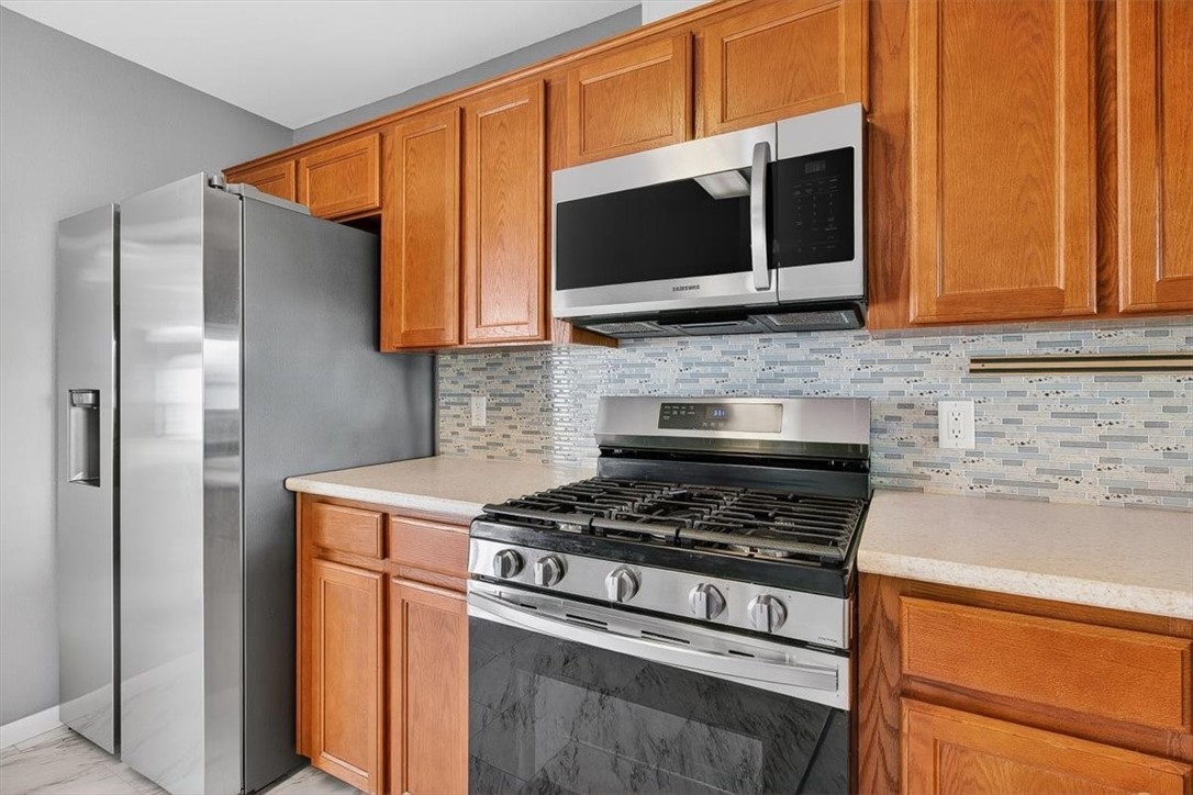 850 Purdue Road Corpus Christi, TX 78418 - Photo 15 of 39 a kitchen with stainless steel appliances wooden cabinets and a stove top oven