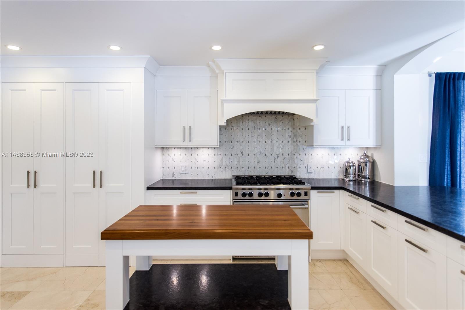 3500 Munroe Drive Coconut Grove, FL 33133 - Photo 11 of 54 a kitchen with kitchen island a stove a sink and a counter space
