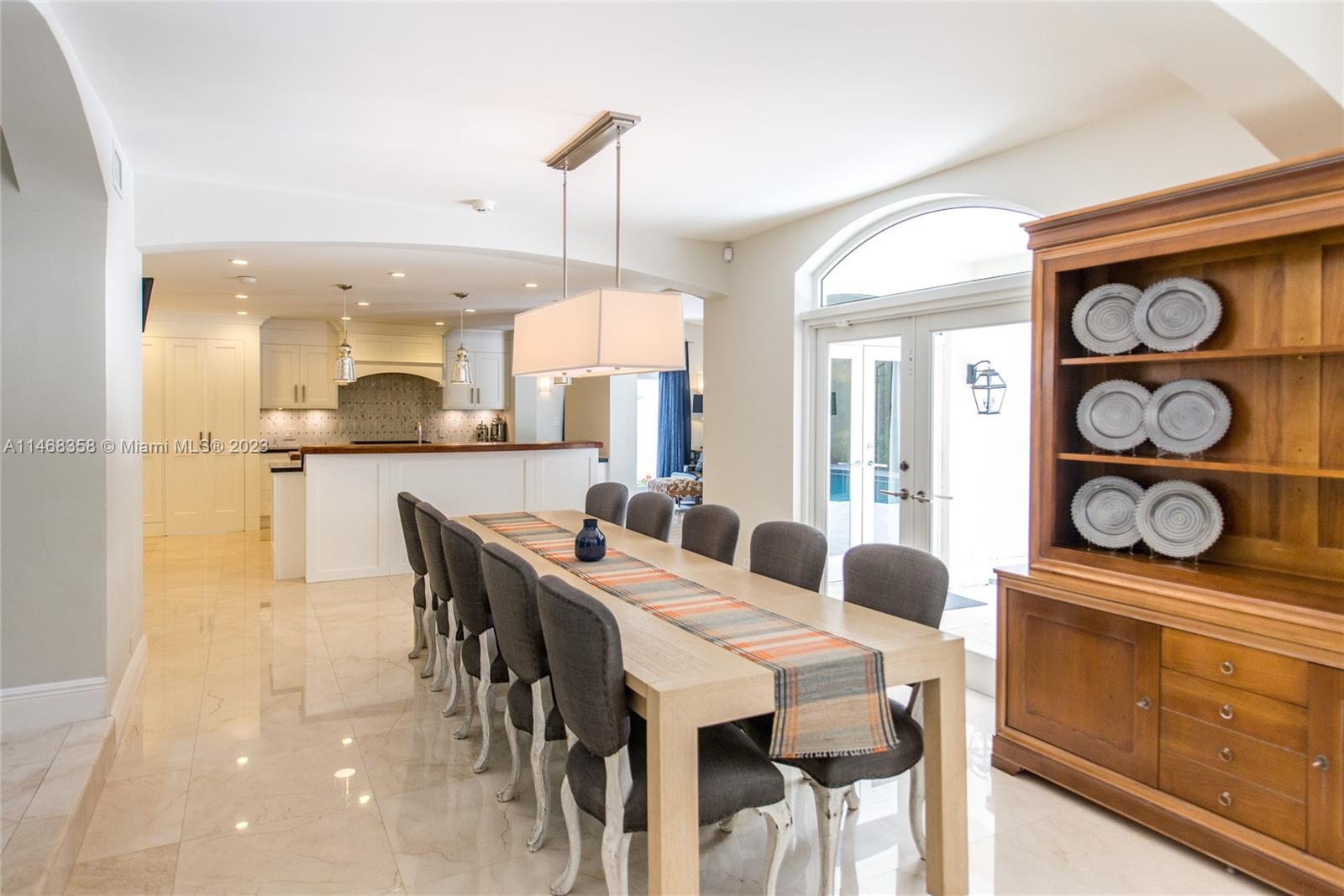 3500 Munroe Drive Coconut Grove, FL 33133 - Photo 16 of 54 a dining area with stainless steel appliances kitchen island granite countertop a table chairs and a refrigerator