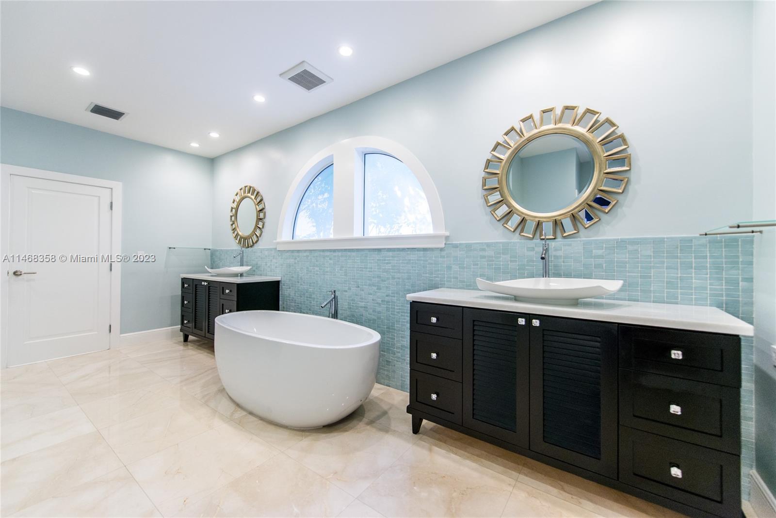 3500 Munroe Drive Coconut Grove, FL 33133 - Photo 28 of 54 a spacious bathroom with a double vanity sink and a mirror